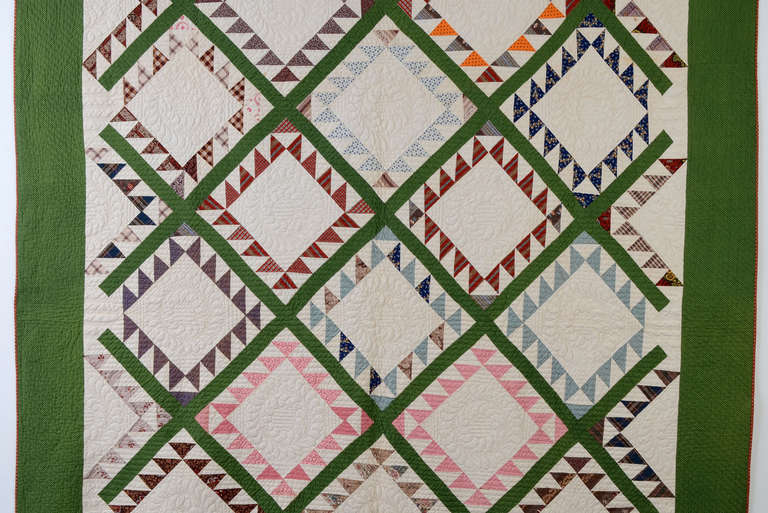 Beautiful Feathered Diamonds Quilt with a diagonal sashing. The white open diamonds highlight the fine quilting of feather patterns. The sawteeth, or feathers, are done with a wonderful variety of fabrics. Excellent, unwashed condition. Measures 80