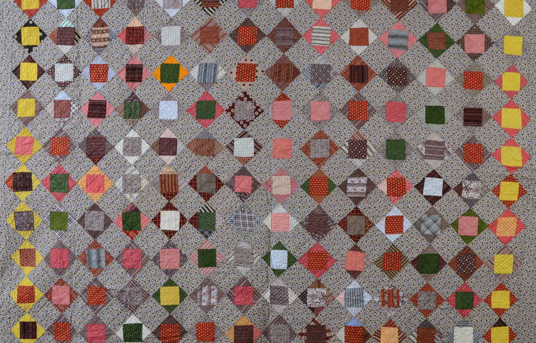 Squares within squares such as this are called an Economy Patch quilt pattern. It is made of a terrific combination of late 19th century printed fabrics. Consistent use of yellow squares on the outer edge make a clever differentiation while actually