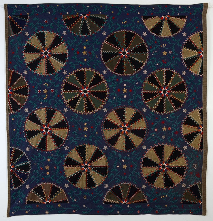 Anyone who thinks of the Amish as drab hasn't seen this quilt. It is imaginative and exuberant.  Medium/ light weight wools are heavily embroidered to create an extraordinary surface. The circles are centered with finely made compasses illustrative