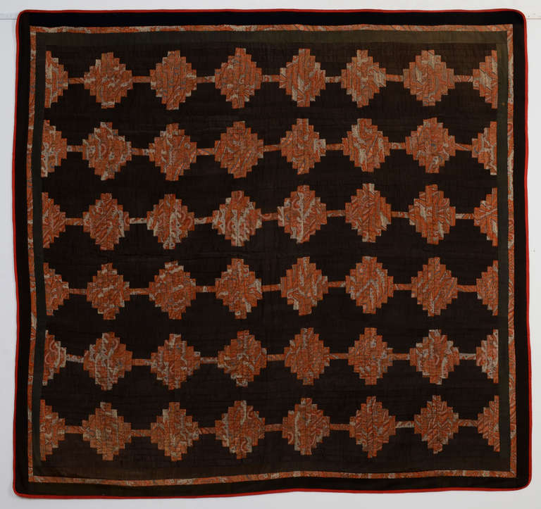 Very sophisticated Courthouse Steps Log Cabin Quilt using a paisley shawl for the patterned fabric. It is wool throughout. The pattern looks quite different but equally effective whether viewed vertically or horizontally. Measures 68