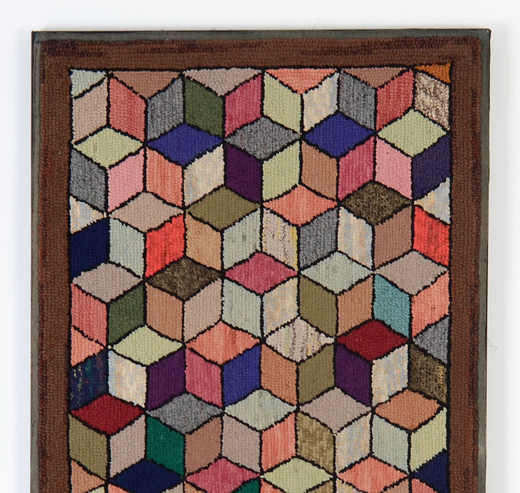 This wonderfully three dimensional hooked rug has appeal on several counts. It is very much like the 19th century Tumbling Blocks quilt pattern. At the same time, it has the effect of  early 20th century Cubist design. The rug is mounted on a
