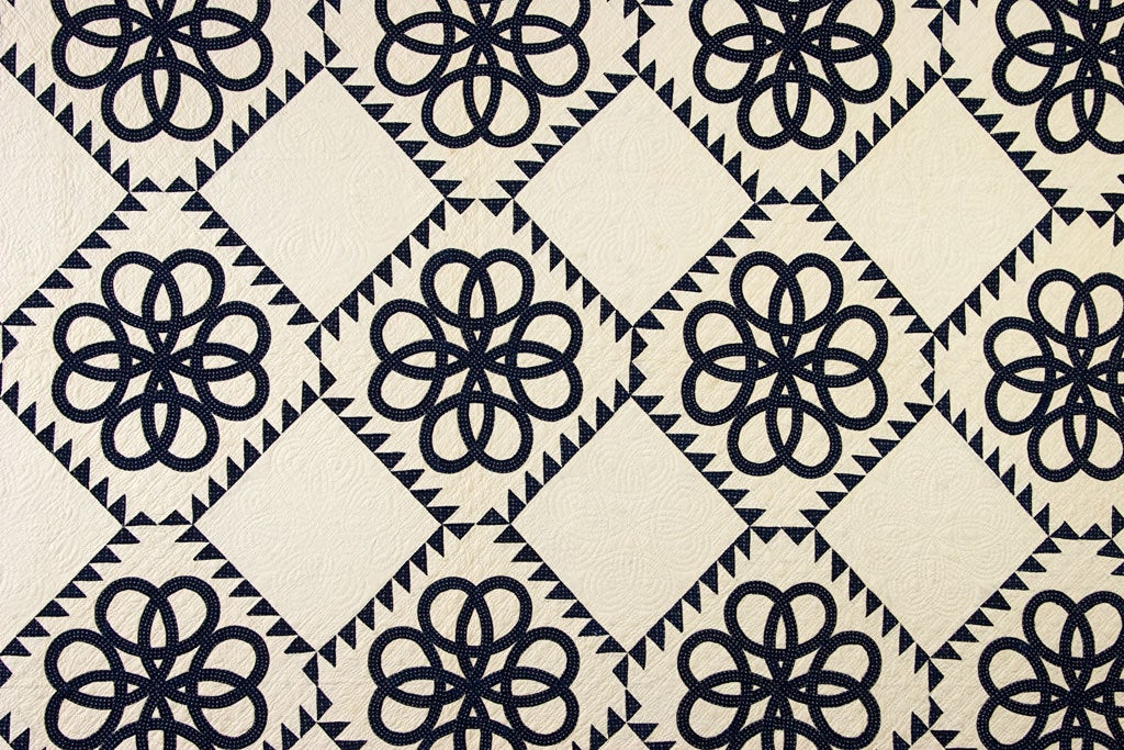 This unique quilt resembling Celtic Knots is outstanding in both its conception and execution. Curved pieces and points are the most difficult to execute and this quilt is made entirely of both. The quilting patterns in the white blocks echo the