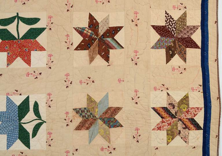 This is an early and unusual quilt combining LeMoyne Stars and Tulip patterns. It is made with a wonderful array of early 19th century fabrics. The tan sashing  was the perfect color choice to blend with the blues; browns and pinks of the quilt.