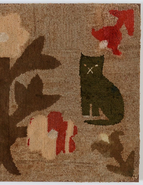 This charming hooked rug shows two cats with a variety of flowers of vastly different sizes and shapes. Its soft colors are brightened by the judicious use of red. Pennsylvania origin. The rug is professionally mounted on a stretcher. A companion