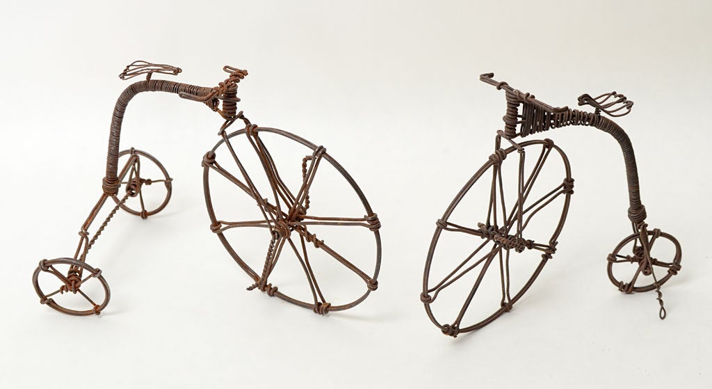 Ces deux sculptures en fil de fer finement détaillées représentent des bicyclettes légèrement différentes. La pièce de gauche est en fait un tricycle et celle de droite est ce que l'on appelle un bonecruncher. Les deux sont en excellent état. Ils