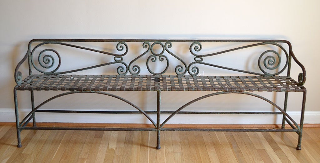 This graceful iron garden bench from France is heavy in weight but light in feel. The lattice seat and curlicue back and arms make for a very graceful statement.
It has remnants of the original green paint. This functional piece of sculpture would
