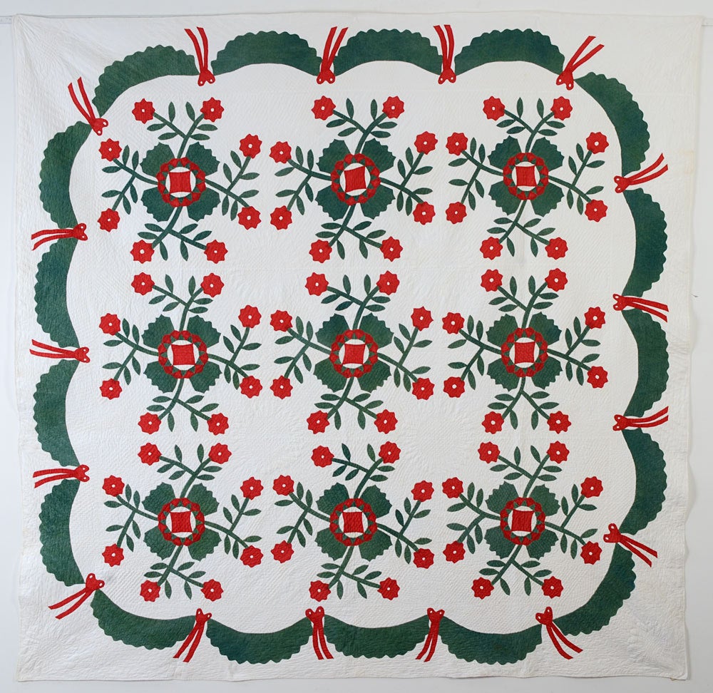 This is a beautifully made example of a classic applique quilt pattern that goes by the names of California Rose and Whig Rose.  Wreaths are quilted in the white areas between the flowers as well as in the corners. The swag and tassel border is a