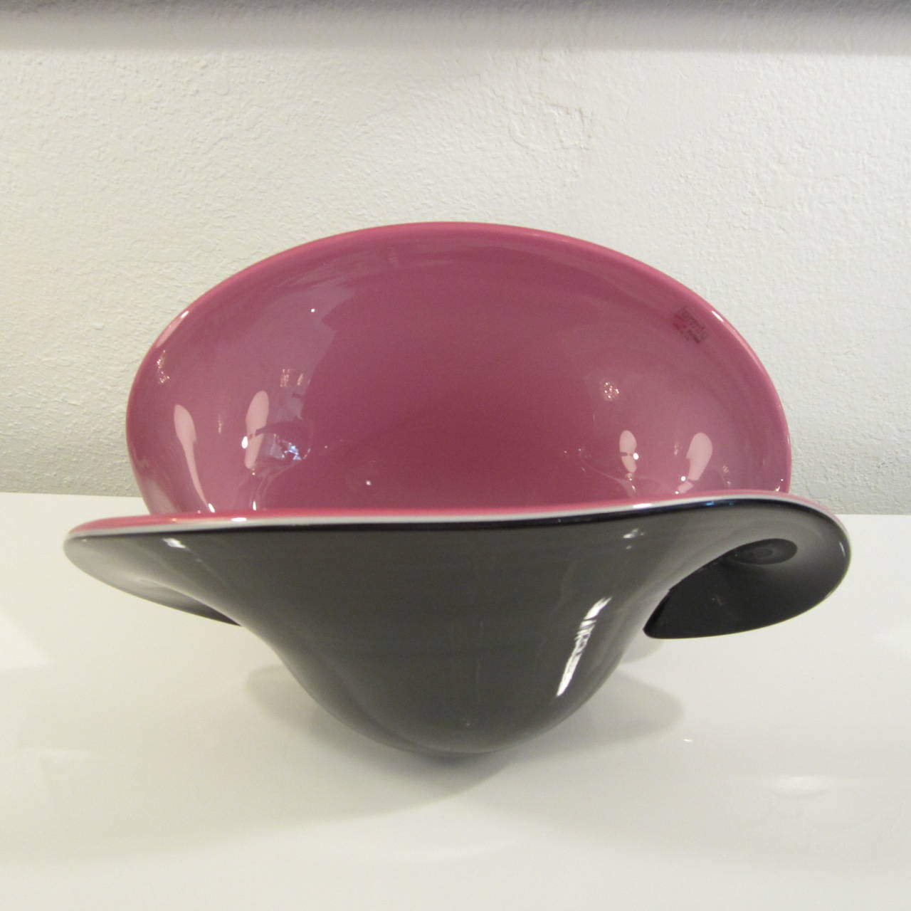 Impressive in size and shape, this two-tone, black and rich pink, shell bowl or vase or vessel has turned down sides and retains its original sticker. As seen in the images, it can be displayed in two ways as it has two separate flat bottoms.