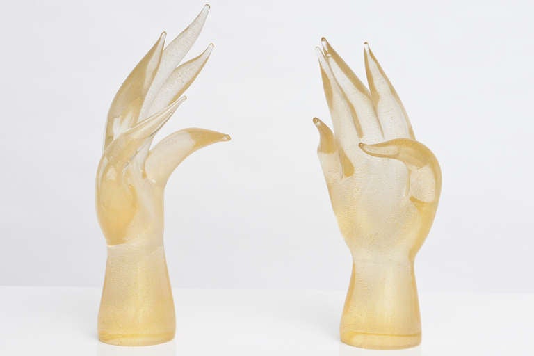 Stunning pair of hand blown Murano glass hand sculptures. Each hand is filled with aventurine and has the signature 