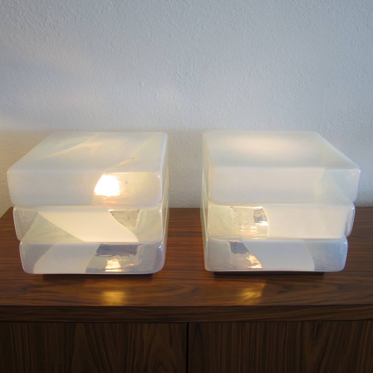 A rare find pair of handblown Murano glass stacked cube lamps designed by Carlo Nason for Mazzega. 
The stacked cubes have organic color variations of opaque blue and white. Sold as a pair. Beautiful colors and warm glow when on. Great for the