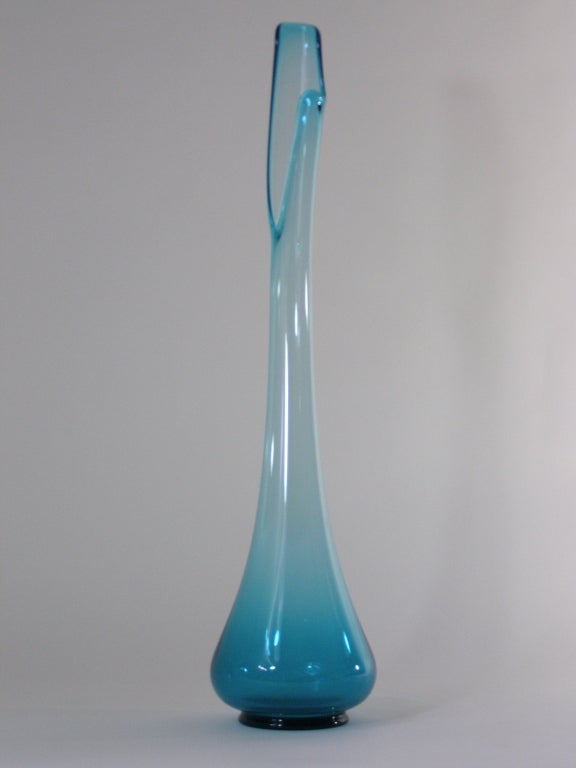 Glass vase with long neck and organic top opening.