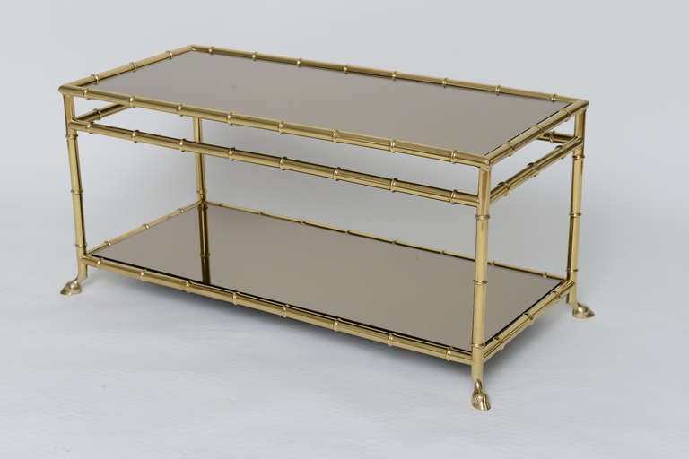 Polished brass bamboo design cocktail table with two bronze mirrored glass tiers and ram's foot feet in the manner of Maison Jansen. Very elegant and sturdy table, can be turned into bench if desired.
