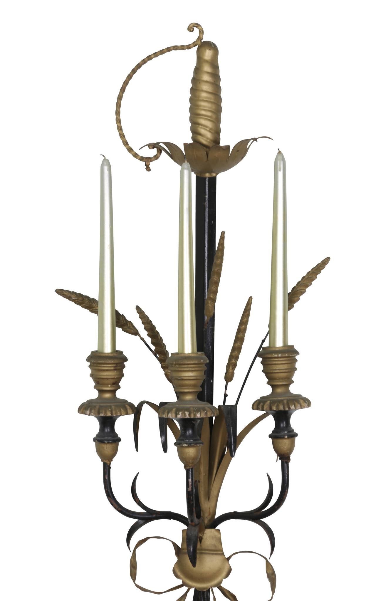 Fantastic pair of Italian tole and gold painted wood wall sconces fitted for candles. Adorned with swords and wheat, they retain the original metal Made in Italy tag. Sold as a pair showing a lot of natural wear from age and use. Candles not