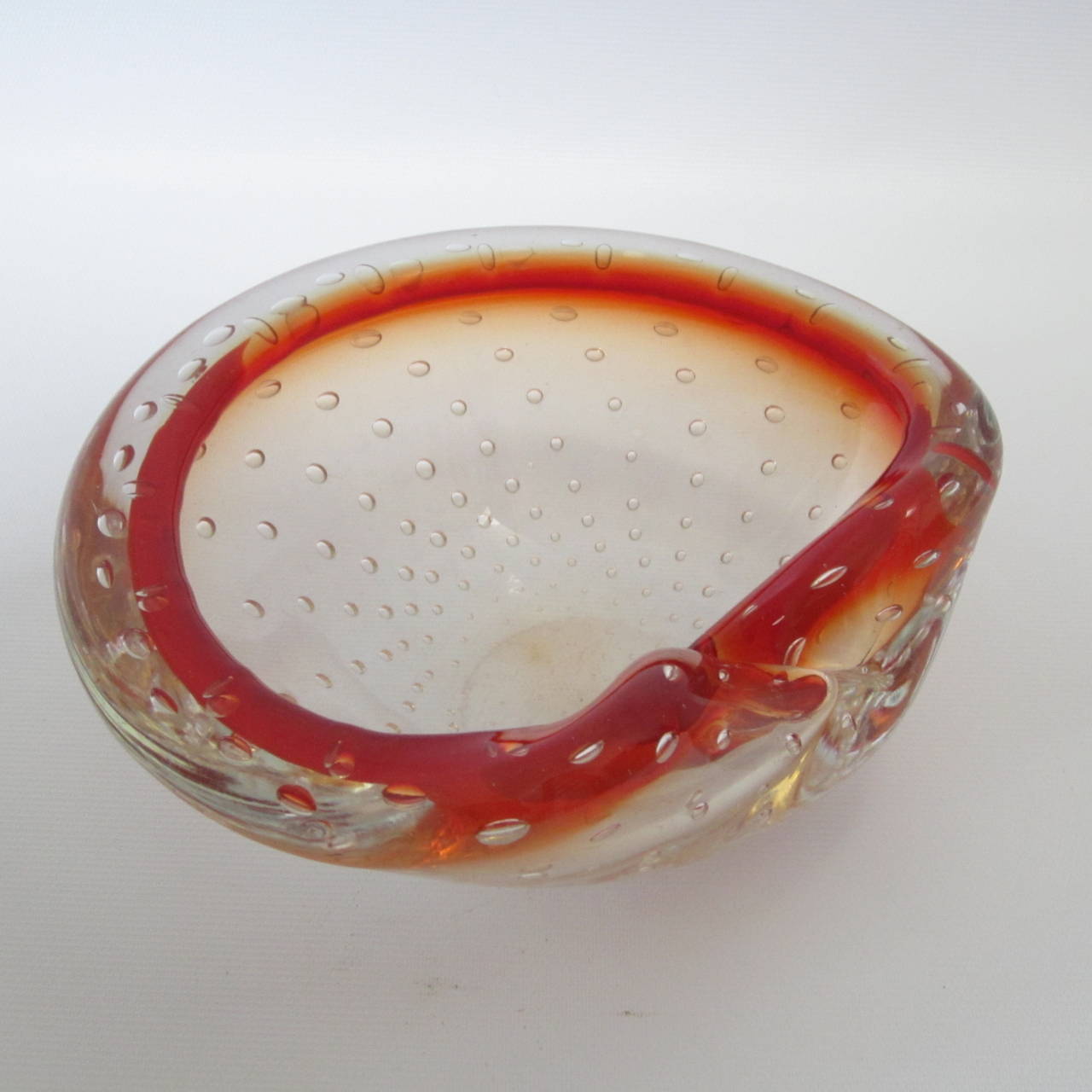 Lovely handblown Murano glass dish or bowl with turned down side. Clear glass filled with bubble inclusions while rim is deep orange.