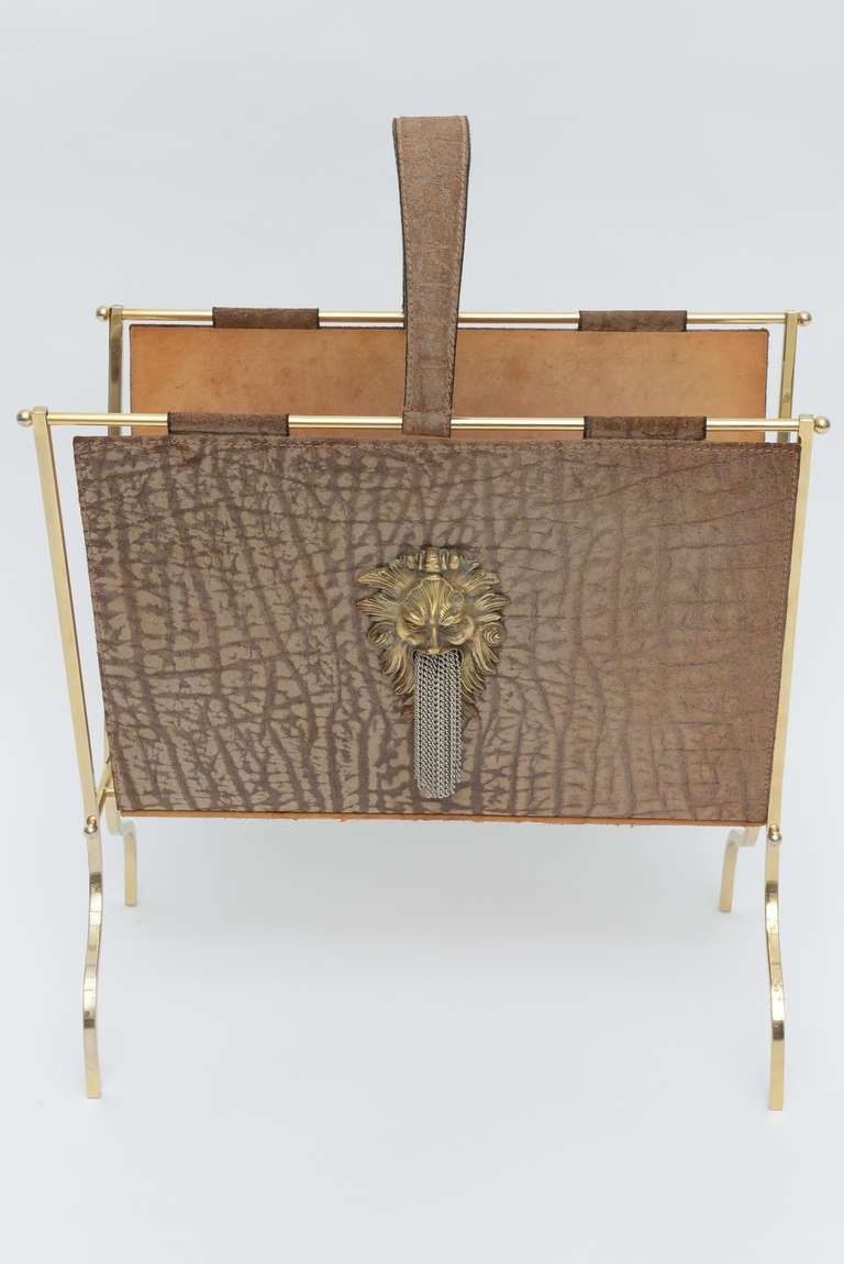 Fabulous embossed suede magazine holder with polished brass frame and patinated lions head center decoration with flowing chains out of its mouth. Visible worn areas on suede but in excellent vintage condition.