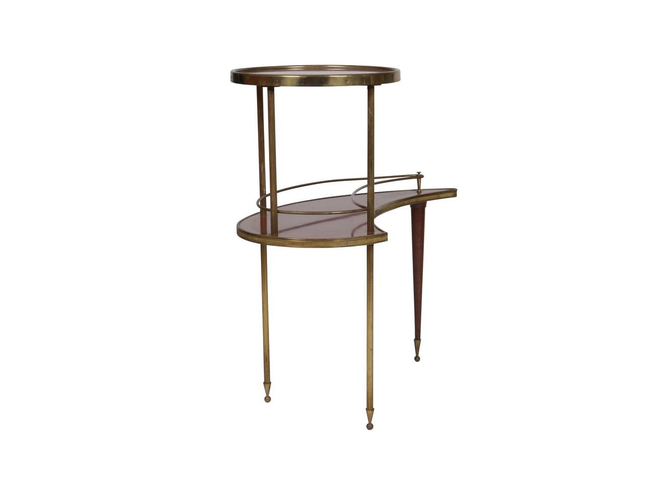 Side table comprised of two wood grain laminate tiers; the top being round and the lower tier organically shaped. The legs are ribbed brass that terminate with brass cone and ball feet. The front leg is wood tapering to a fine point with matched