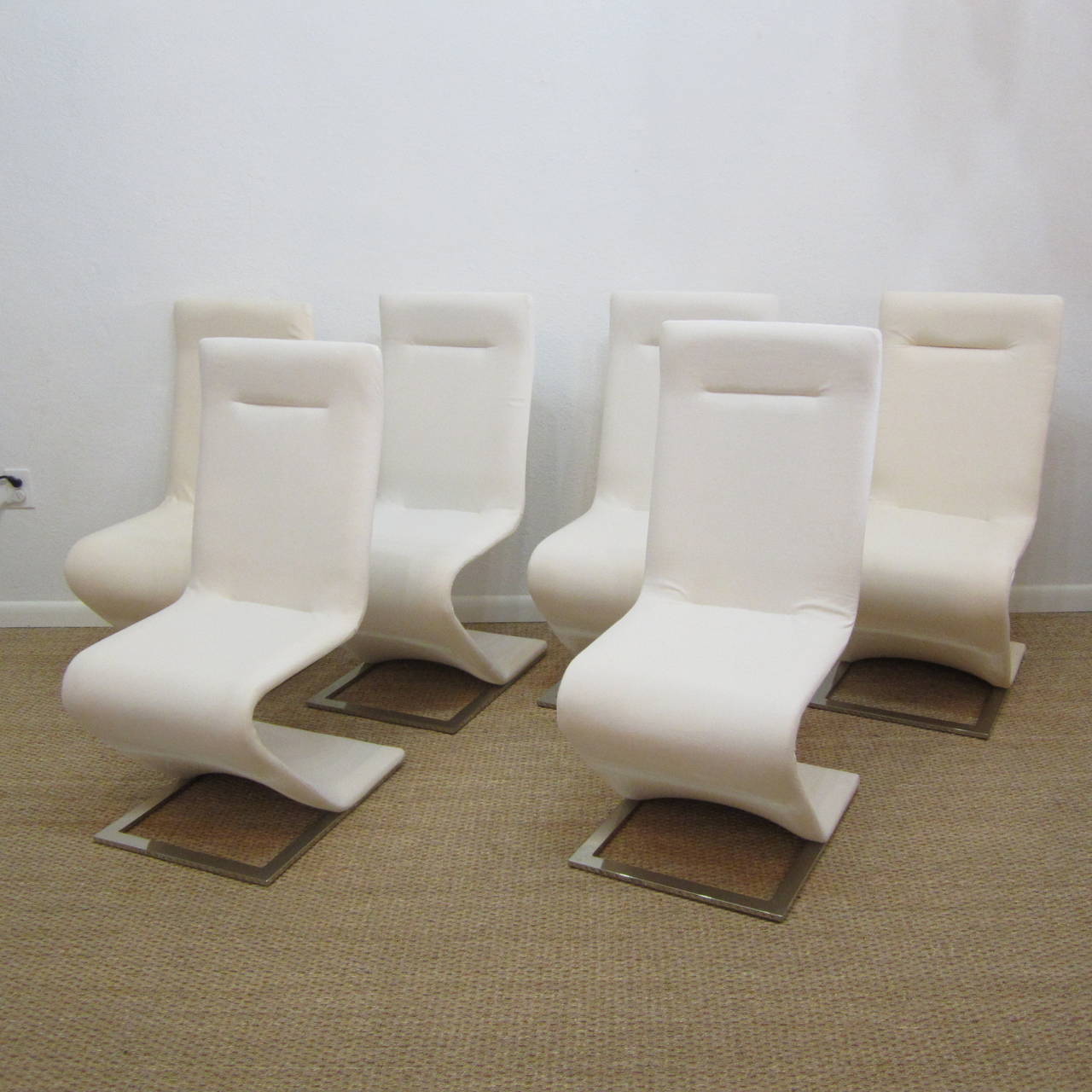 Original elegant cantilevered dining, office or side chairs on solid and weighty polished steel frames. Chairs have a perfect back and forth sway to them, are a rare find, and have visible scuff wear to the fabric but are very solid and study steel