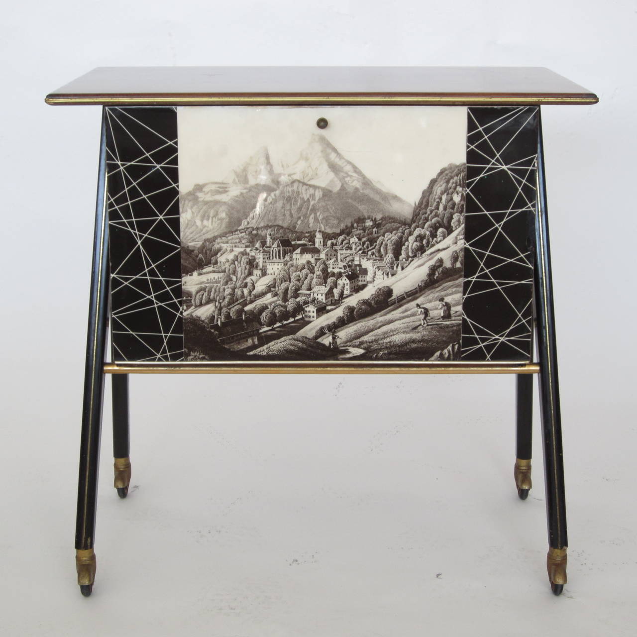 Fantastic Italian bar on four A-frame legs with original wheels in fine working condition. The front design on the door depicts a mountainous scene in Italy with black and white 1950s motif flanking it. When door opens it reveals this great crackled