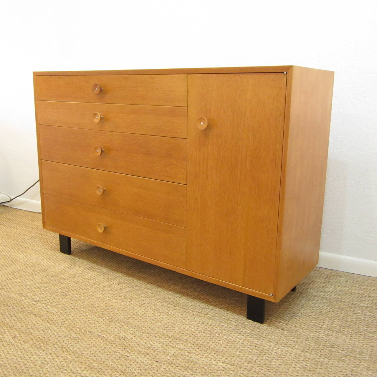 George Nelson for Herman Miller solid white oak cabinet featuring five drawers and single door, which reveals two adjustable shelves. Several drawers are compartmentalized and the top drawer retains the original Herman Miller/George Nelson signature