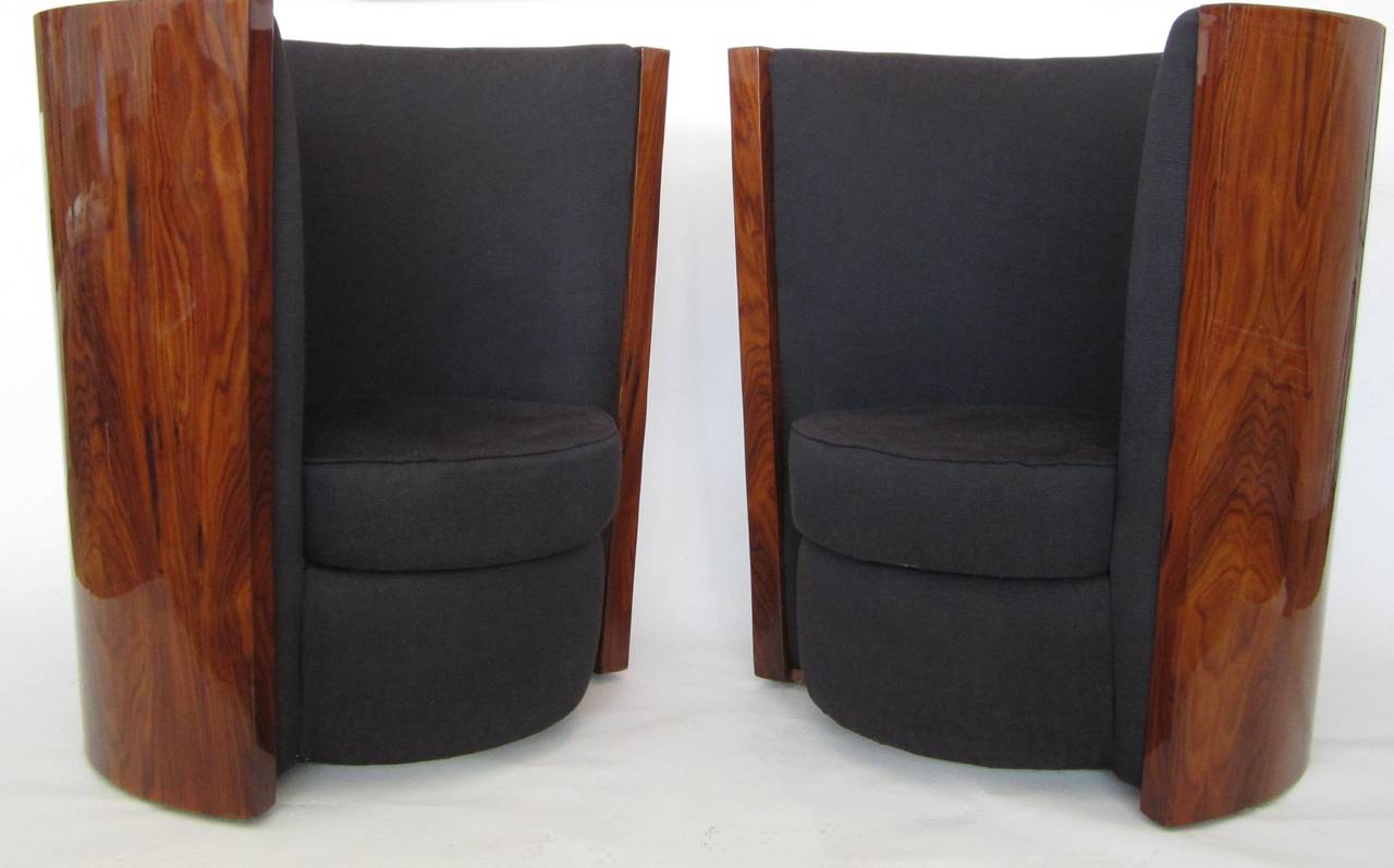 Unique pair of conversation chairs with curved cherrywood backs and cushioned interiors. They are wider at the top offering this wonderful shape. The wood had been exquisitely restored. The upholstery is an Industrial type of fabric which works well