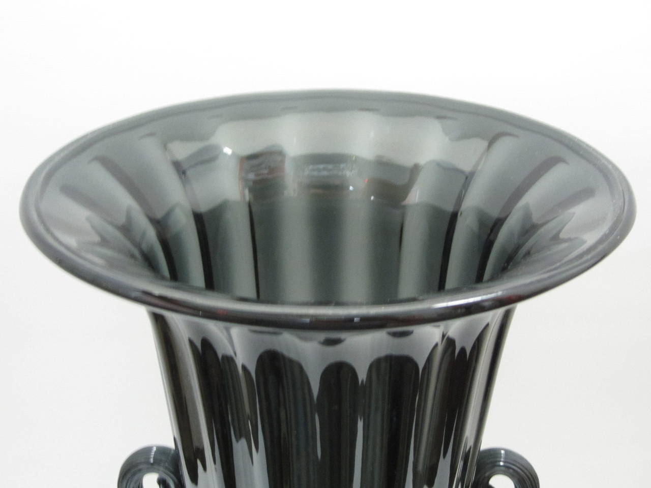 Fantastic tall trumpet-shaped urn vase in ribbed charcoal colored slightly iridescent glass. The applied glass handles are thicker with a tighter ribbed design. Inscribed signature reads 