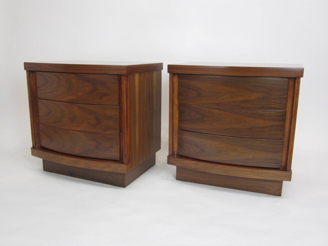 Pair of side tables each with three curved-front drawers and tops. Recessed plinth and touch-latch drawers. Finely finished inside and out. Sold as pair.