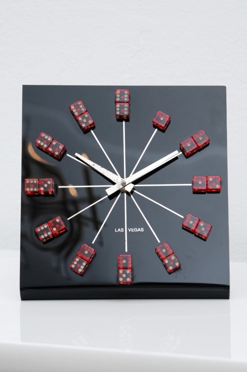Fun black acrylic clock with red dice depicting the hour--the amount of the dice equals the hour all the way to 12 o'clock which shows the two dice with sixes. Originally sold through Bergdorf Goodman in New York City.