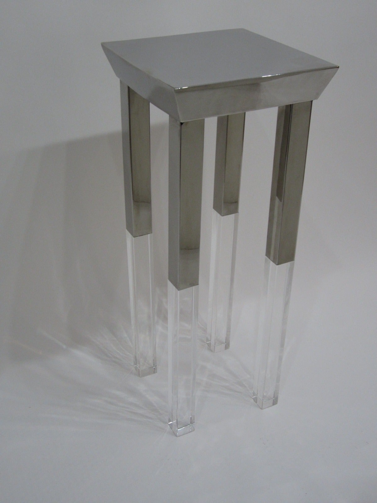 Gorgeous polished steel-top and partial leg side table with the balance of the legs in Lucite block. The sides of the top surface are inverted creating this fantastic look. Great as a lamp or sculpture table. Visible welding on bottom of table in