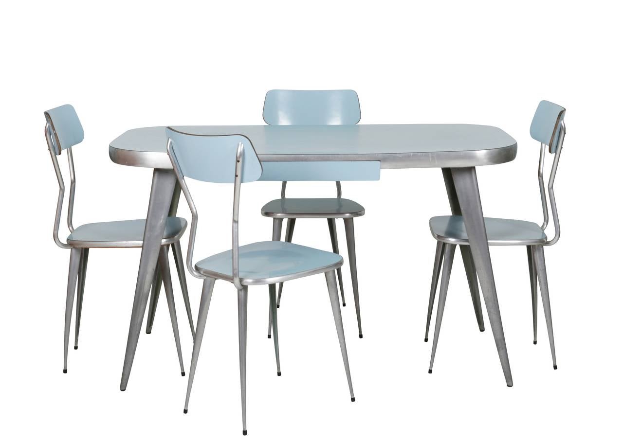 Found in the permanent collections of both MOMA in New York City and the Victoria and Albert Museum in London, this fantastic and rare powder blue laminate and aluminum dining table with four matching chairs was designed and manufactured by Ernest