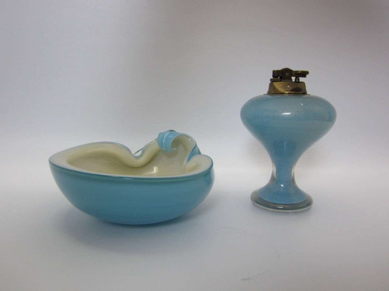 1950s Murano glass smoke set consisting of a Venetian-blue flip-top dish with off white interior filled with gold flecking and a rare matching mushroom shaped tabletop lighter. Designed and manufactured by Alfredo Barbini both documented in a 1950s