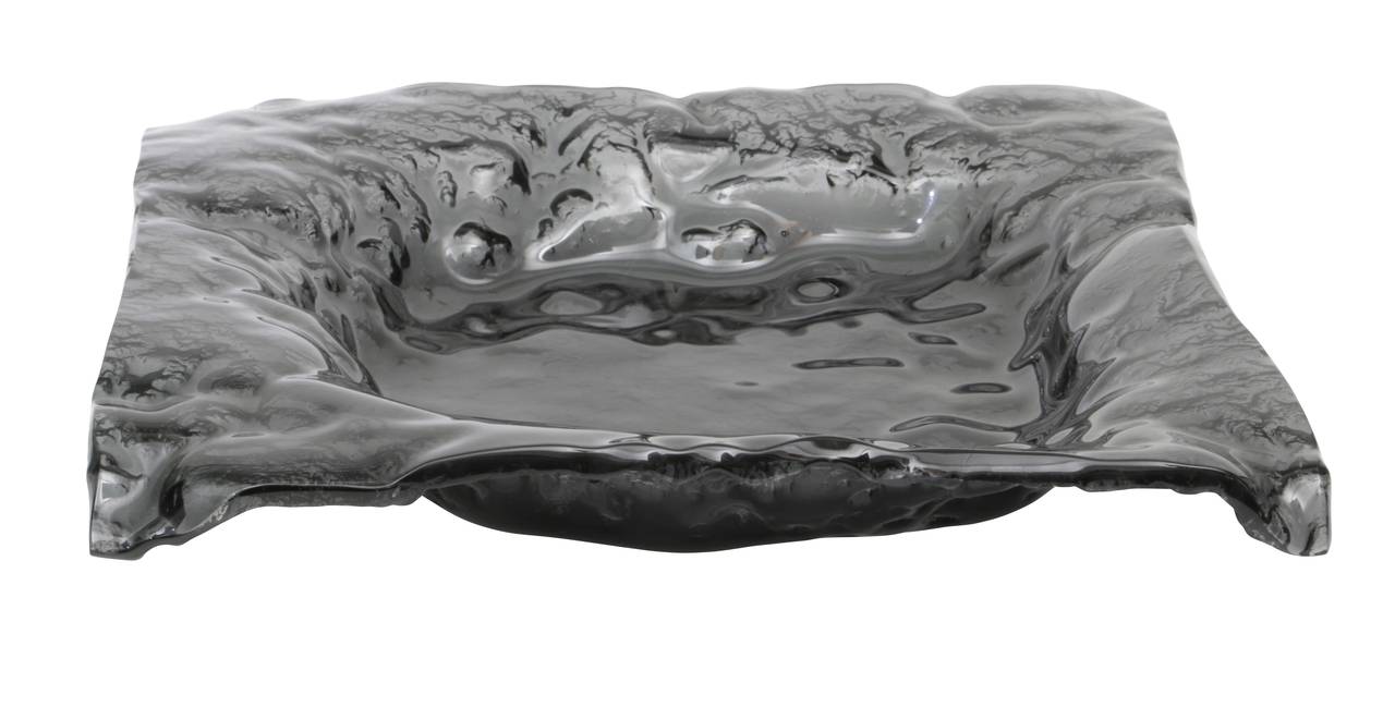 Wonderful charcoal/black art glass low profile bowl molded in a lava effect with turned down corners. Beautifully executed. Weighty.