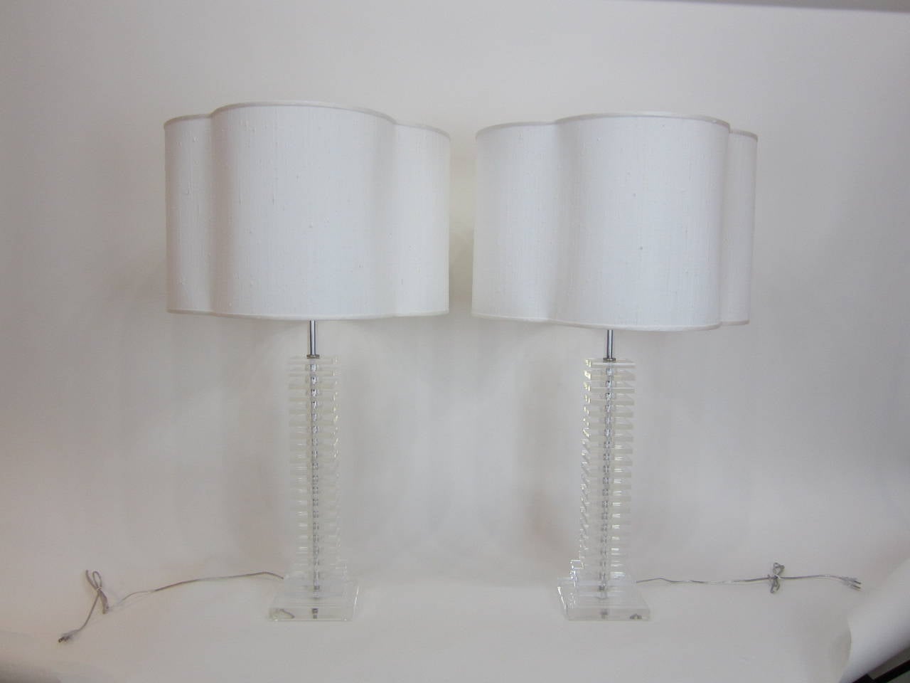 Tall and elegant pair of sliced and stacked lucite lamps fully rewired and appointed with nickel fittings and complimented with custom raw silk quatrefoil shades. 