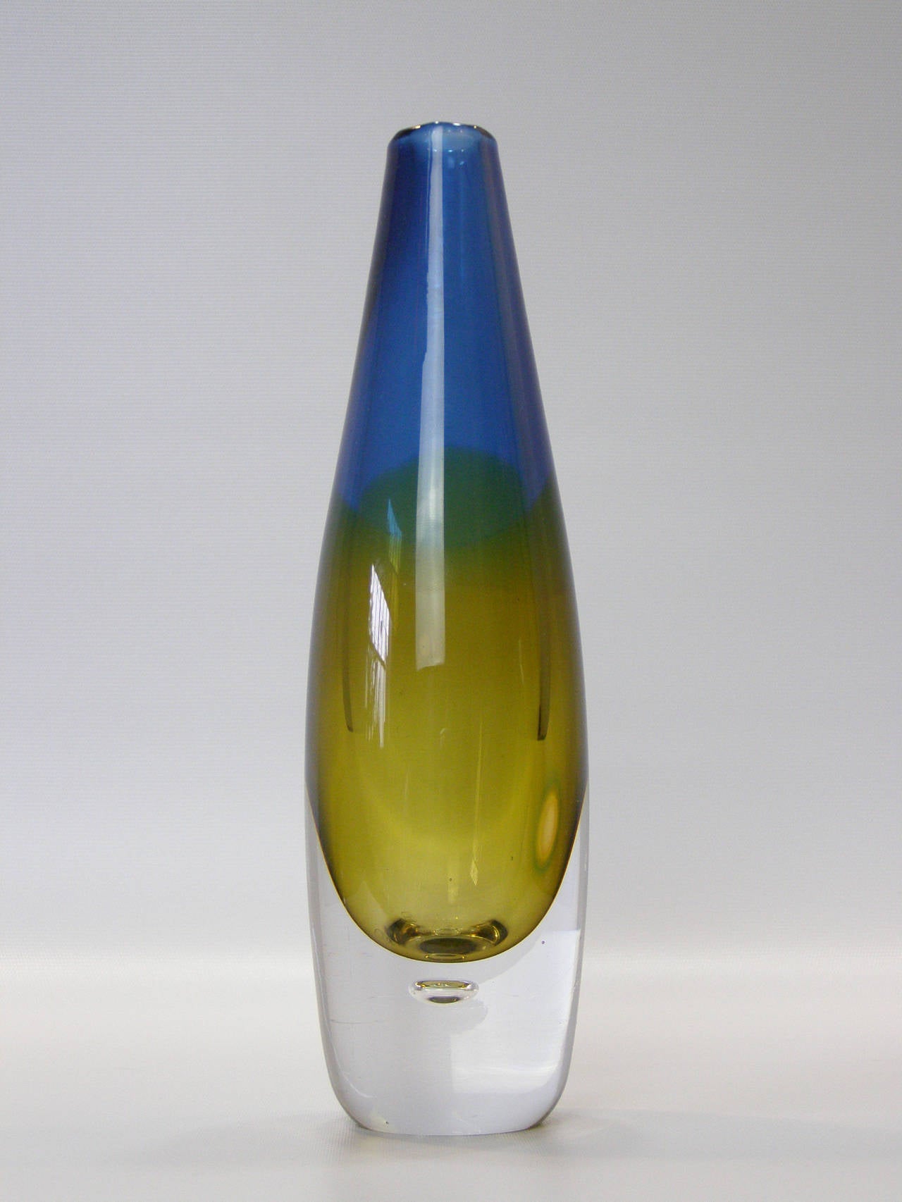 Beautiful blown glass vase in two-tone amber and blue. Blown in the Sommerso technique with controlled bubble within base. Signed on underside along with Crown Kosta Sweden sticker on lower side.