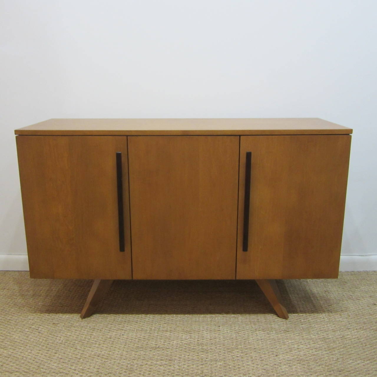 Three-door cabinet made of ash wood with a continuous interior shelf. Original cleat door pulls in a darker wood. Excellent original condition. Great as a server as well as a general store-all.