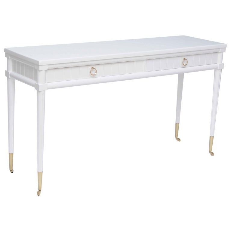 Console table finished in high gloss white lacquer with original polished brass ring pulls and sabots with wheels. The ring pulls appear to be for drawers yet they pull out small drinks tables which unfold and can be used individually and separately