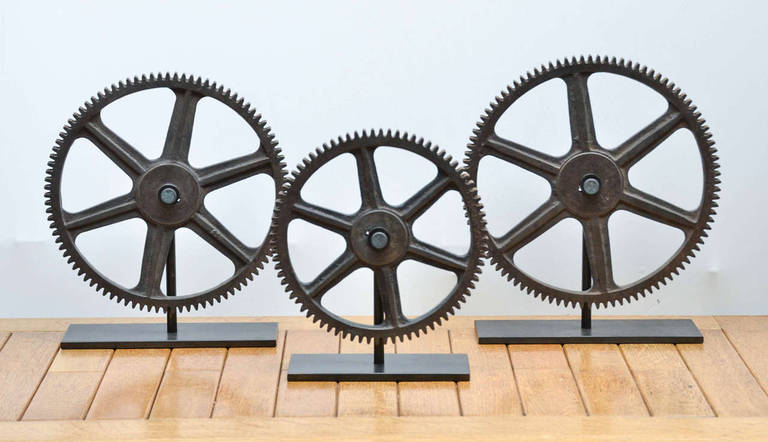 Vintage Industrial Bronze Gears displayed on metal stands.