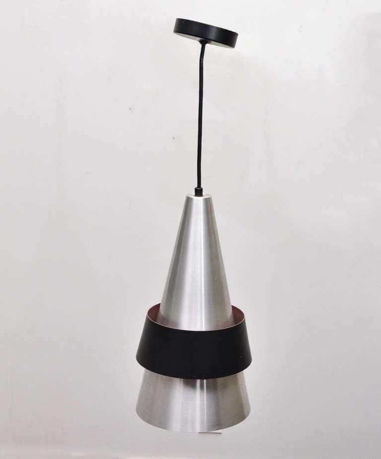 Mid-century Danish aluminum conical pendant light.

The aluminum, cone-shaped part of this pendant has a sleek break so that light reflects off of the black band as well as through the bottom of the fixture. 
 