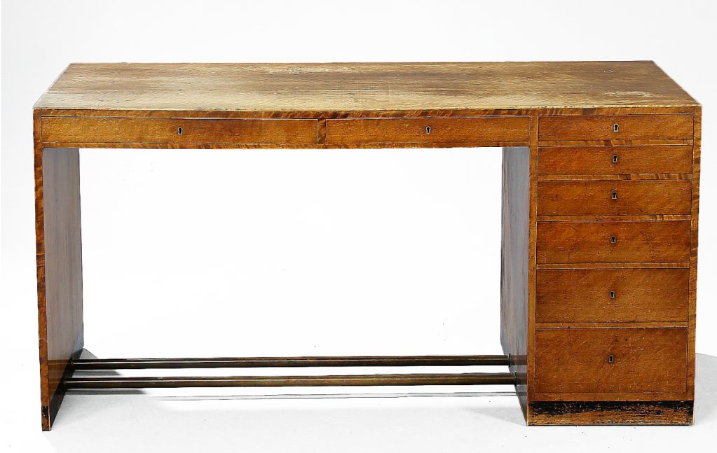 Early desk by cabinetmaker Jacob Kjaer of highly figured Birch, brass and black lacquered base. Solid birch construction c. 1935

Two drawers under writing surface.  Bank of six drawers composing the pedestal base.