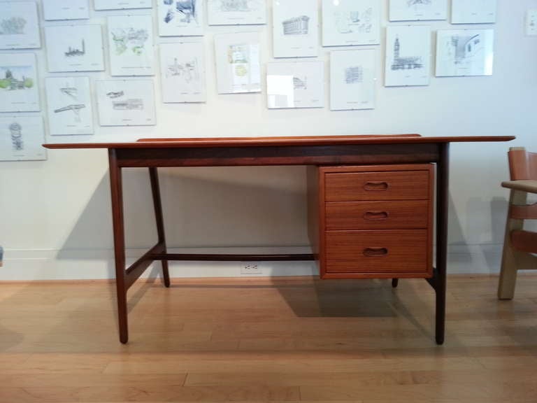 Perfectly proportioned teak desk or writing table by Arne Vodder, manufactured by Sibast Mobler c. 1961.  Iconic rear lip detail, oval handles and contrasting strains of teak complete the open frame design.

Immaculate, care for original condition.