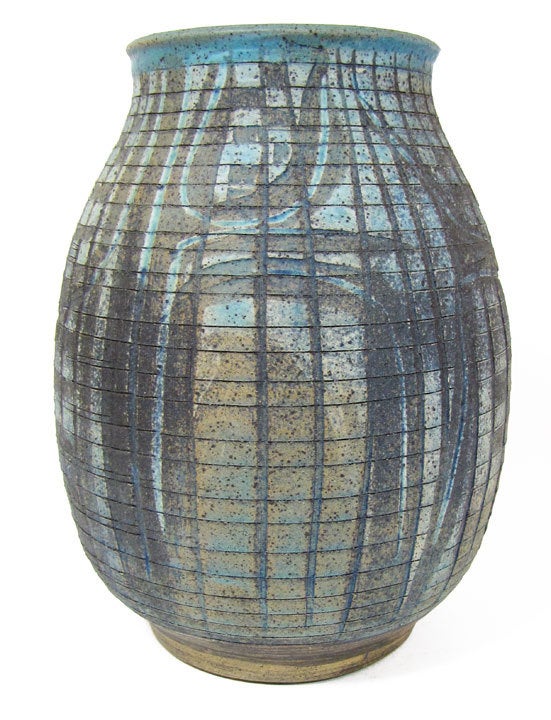 Sublime vase having heavy organic primitive stylized carvings by Charles Counts with a thorough blue glaze wash. Perfect proportions, decoration, and glaze come together for an inspired piece of pottery by master ceramicist, Charles Counts.