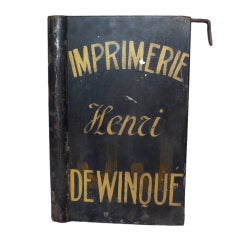 A Painted Tin Tipography Trade Sign Depicting A Book.