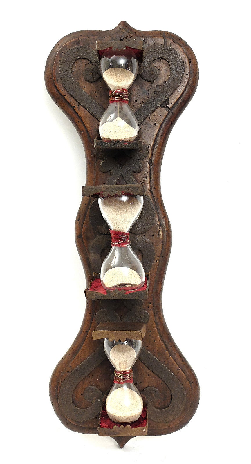 Convent wall hourglass with three bulbs, made out of walnut wood with  iron supports to hold the hourglasses. Inside, the elements are made from blown glass, connected to the center of a ring constructed with fragments of velvet and metal wires.
