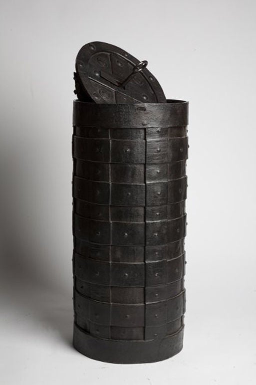 Highly unusual Italian strongbox, made out of iron, cylinder shaped, emulating a barrel. The structure is made by intersecting vertical and horizontal iron strips secured by rivets. One of the two circular sides, identical, hides a secret. By