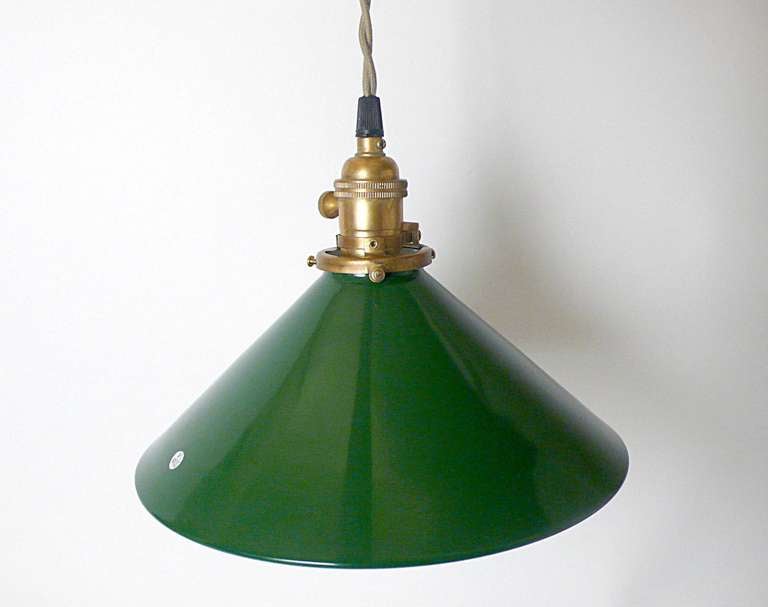 Rare and unusual green enameled metal swinging industrial lamps from a tailoring factory, made out of metal and mirrors, trapezium shape, to reflect the light.