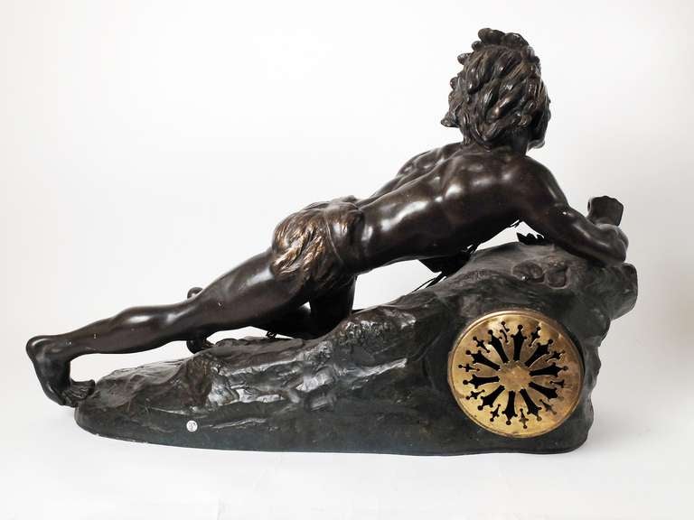 A beautiful white metal sculpture clock, with perfect patina, depicting a native American chief with a bow, laying down over a rock, ambushing. France