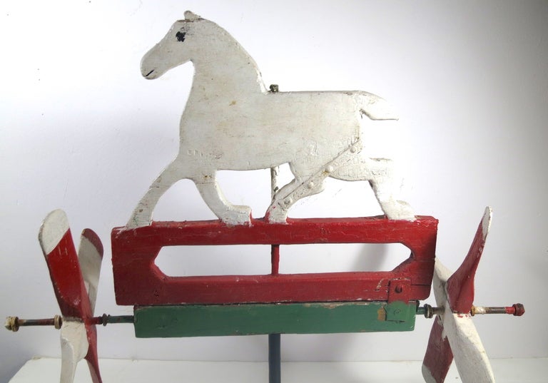 A pair of red and white propellers whirl around this fanciful white horse silhouette from the 1940's, museum iron mount. 