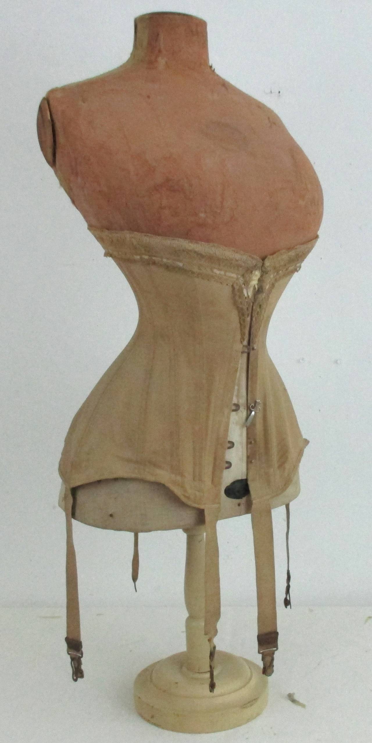 Great 1890's corset and form with the original paper label. Made by the J. Kindliman Form Company 419-420 Broome Street, NY. The papier mache had/has a fabric covering, much of this is missing but that doesn't alter the overall interest of this