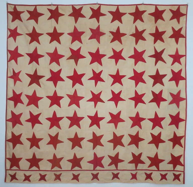 Very graphic red stars on a muslin background. the stars are hand sewn, the muslin squares and the red border are machine sewn. Exuberant and very lively expression of patriotism. The stars have various fading which adds to the depth of expression.