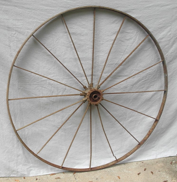 A wonderful and monumental 19th iron tractor wheel, beautiful center spoke attachment