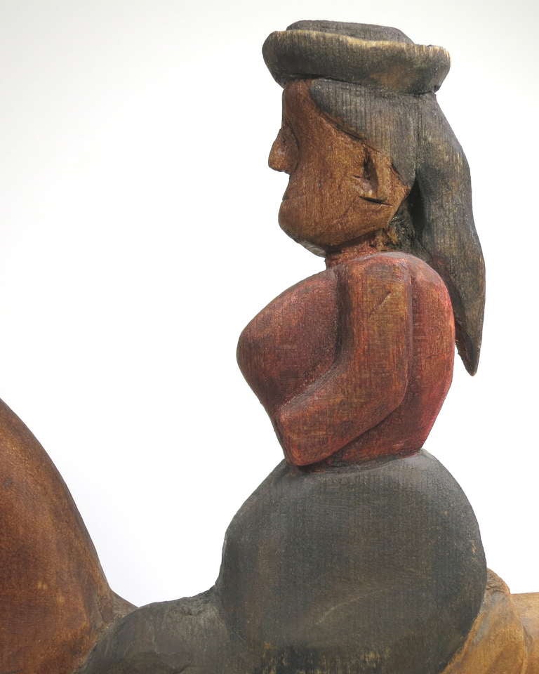 Intriguing pine carving of a woman riding side saddle, unpainted wood with a polychrome wash. Some graphite details and leather 